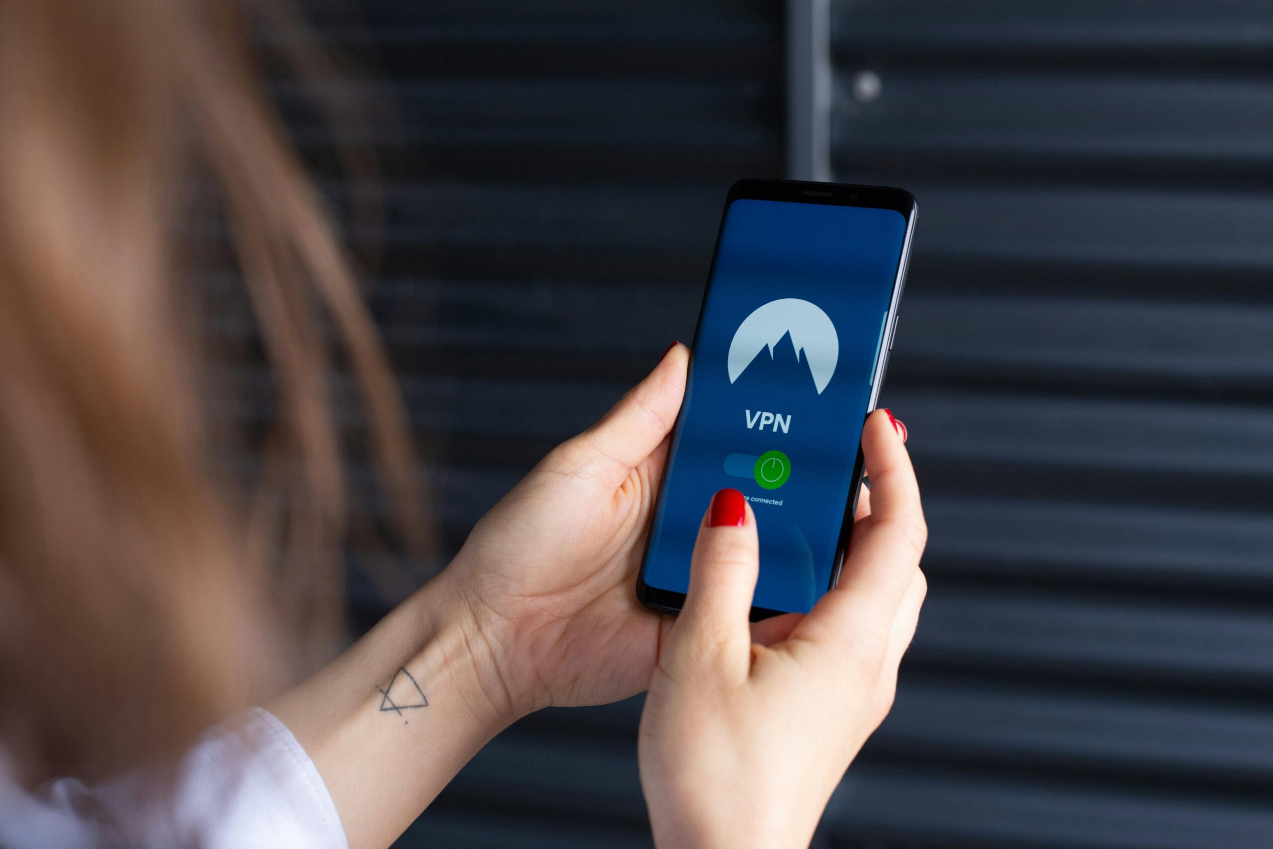 Mobile Privacy Mirage: How Fake Permissions Fool Users in 2025 Close-up of a woman's hands using a VPN app on a smartphone, emphasizing digital security.