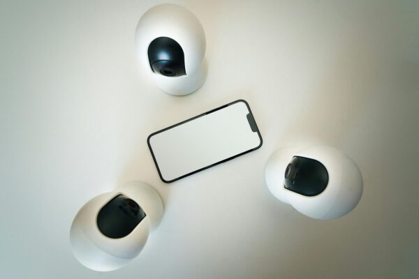 Mobile Surveillance: How Smartphones Became the Ultimate Spying Tool Smartphone surrounded by security cameras on a modern, minimalist setup.